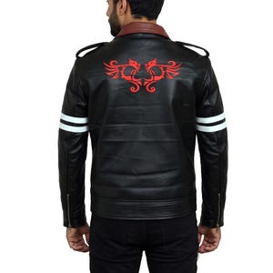 Könnte beinhalten: Eine schwarze Jacke mit braunem Kragen, Schulterklappen und langen Ärmeln mit zwei horizontalen weißen Streifen. Auf der Rückseite befindet sich eine rote Grafik von zwei symmetrischen, drachenartigen Wesen mit ausgebreiteten Flügeln.