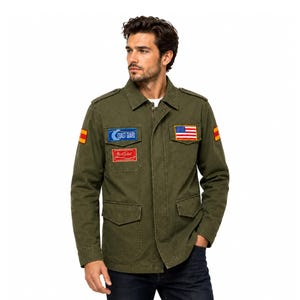Könnte beinhalten: Eine olivgrüne Feldjacke im Militärstil mit Frontreißverschluss, zwei Brusttaschen und zwei unteren Taschen. Zu den Aufnähern gehören ein blaues Coast Guard-Emblem, ein roter rechteckiger Aufnäher und eine Flagge der Vereinigten Staaten.