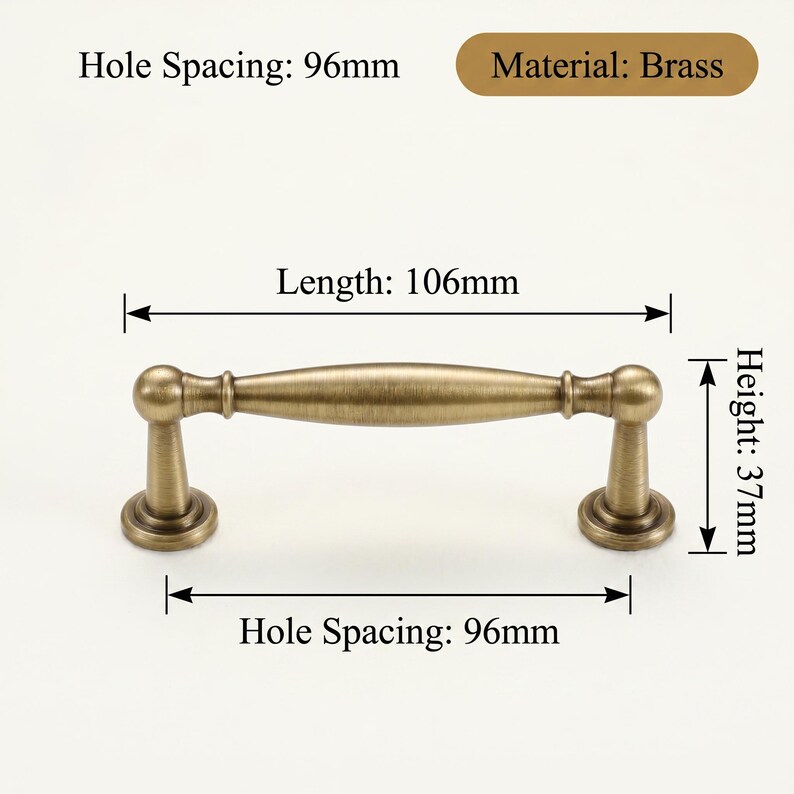 May include: Antique brass cabinet pull, 106mm long and 37mm high, with 96mm hole spacing. Made of brass, it features a classic design with rounded ends and a central handle. The text reads: 'Material: Brass'.