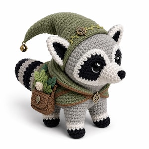 May include: A crocheted raccoon figurine featuring grey and black fur, wearing a green hooded cloak with a small metal leaf charm and a matching pointed hat topped with a tiny gold bell. A brown crocheted satchel holds small green fabric leaves.