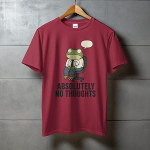 Maroon t-shirt with cartoon frog wearing suit, "ABSOLUTELY NO THOUGHTS" text.