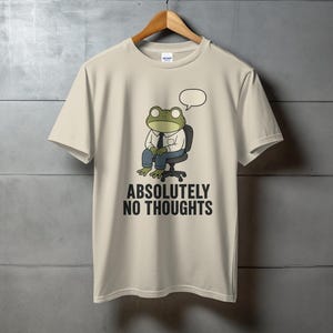 T-shirt with cartoon frog sitting in chair, text "ABSOLUTELY NO THOUGHTS".