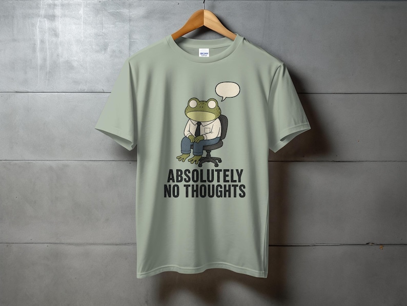 Light green t-shirt with cartoon frog sitting in a chair, "ABSOLUTELY NO THOUGHTS" text.
