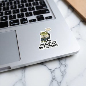 Frog in a suit sitting at a desk, "Absolutely No Thoughts" sticker.