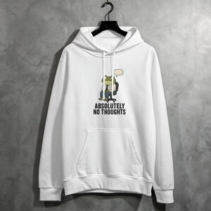 White hoodie with a frog sitting in a chair and the text "ABSOLUTELY NO THOUGHTS".