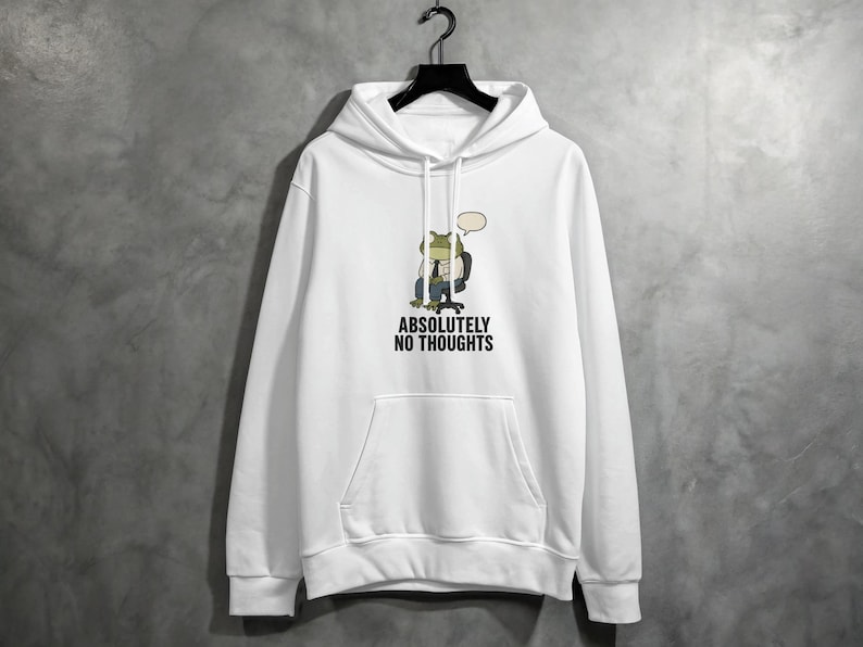 White hoodie with a frog sitting in a chair and the text "ABSOLUTELY NO THOUGHTS".