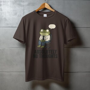 Brown t-shirt with a frog sitting with a speech bubble and the text "ABSOLUTELY NO THOUGHTS".