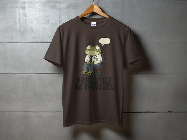 Brown t-shirt with a frog sitting with a speech bubble and the text "ABSOLUTELY NO THOUGHTS".