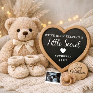 May include: A baby announcement scene featuring a teddy bear, booties, and a heart-shaped chalkboard. The chalkboard reads "We've been keeping a Little Secret" with the month and year. A sonogram and dummy complete the announcement.