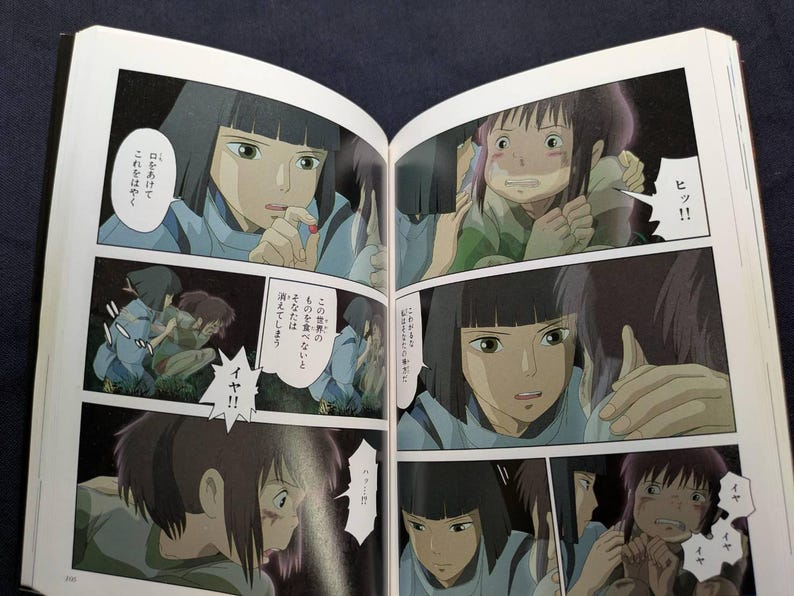 Pode incluir: Livro aberto com pain&eacute;is de mang&aacute; japon&ecirc;s. Os pain&eacute;is retratam uma jovem com cabelo preto curto em uma camisa azul, expressando medo. Bal&otilde;es de fala cont&ecirc;m texto japon&ecirc;s. O mang&aacute; est&aacute; aberto em uma superf&iacute;cie escura.