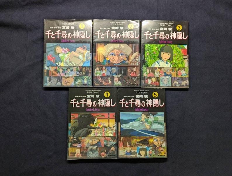 Pode incluir: S&atilde;o apresentadas cinco bandas desenhadas japonesas do filme "A Viagem de Chihiro". Cada livro tem uma capa preta com texto japon&ecirc;s e uma ilustra&ccedil;&atilde;o colorida. Os livros est&atilde;o numerados de 1 a 5. O fundo &eacute; um tecido azul escuro.