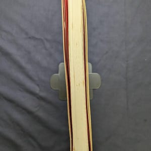 Pu&ograve; includere: Un libro con copertina rigida con una copertina color crema e bordi delle pagine rossi. Il libro &egrave; tenuto in posizione verticale da un leggio grigio. Le pagine sono visibili e il dorso &egrave; leggermente usurato. Lo sfondo &egrave; un tessuto grigio scuro.