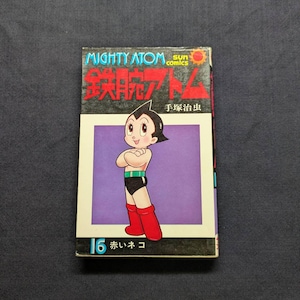 May include: A vintage comic book featuring the character Mighty Atom, with the title in Japanese and English. The cover shows a cartoon robot character in a black outfit and red boots against a purple background. The number 16 and Japanese text are at the bottom.
