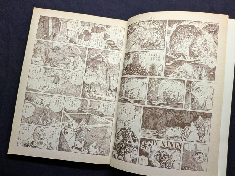 May include: Open book with sepia-toned manga illustrations. The artwork features detailed panels with figures, creatures, and speech bubbles. The style is reminiscent of classic Japanese comics, with a focus on storytelling through sequential art.