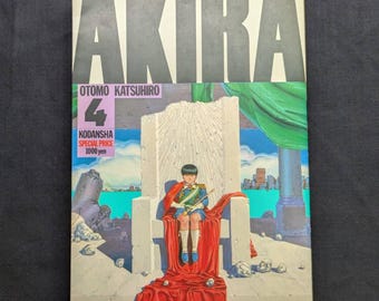 May include: Akira Volume 4 manga book. The cover features a young person in a military-style uniform seated on a throne. The title "AKIRA" is at the top, with the author's name and publisher information below.