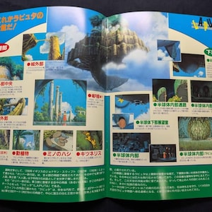 May include: A double-page spread from a Japanese publication featuring illustrations of the floating city Laputa. The layout includes multiple small panels showing architectural details, lush greenery, and characters, with Japanese text throughout.