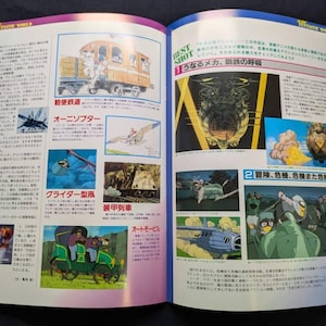May include: An open magazine spread featuring Japanese text and multiple colorful illustrations of mechanical vehicles, aircraft, and animated scenes. The pages display detailed technical drawings and cinematic stills from an animated production.
