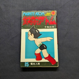 May include: A vintage comic book featuring the character Mighty Atom, with Japanese text and a colorful illustration of the character in action. The cover has a blue background with the number 15.
