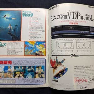 May include: A vintage magazine advertisement for a Toshiba VDP30M video disc player, featuring promotional text, technical specifications, and colorful illustrations from the animated film Castle in the Sky, including a 34cm width measurement.