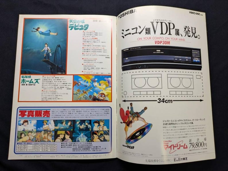 May include: A vintage magazine advertisement for a Toshiba VDP30M video disc player, featuring promotional text, technical specifications, and colorful illustrations from the animated film Castle in the Sky, including a 34cm width measurement.