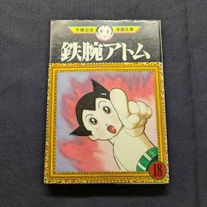 May include: Astro Boy manga volume 18. The cover features a colorful illustration of the character pointing with a surprised expression. The title is in Japanese with a gold frame and a red background.