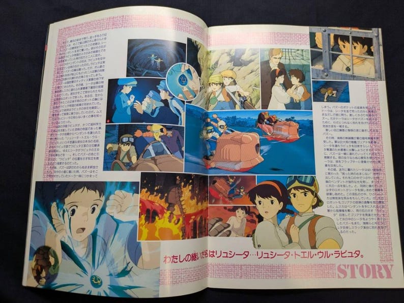 May include: A printed magazine spread featuring multiple colorful anime-style illustrations from the film Castle in the Sky. The pages contain Japanese text, character portraits, action scenes with flying vehicles, and a glowing blue pendant.