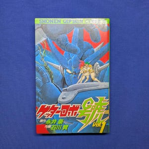 May include: A manga volume titled Getter Robo Go Vol. 1 featuring a large blue mechanical robot and two figures in the foreground. The cover art includes red, blue, and green colors with Japanese text and the English text SHONEN CAPTAIN.