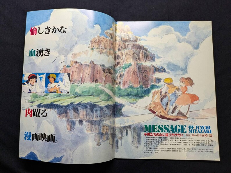May include: A double-page spread illustration featuring a watercolor-style floating castle above clouds, with two small inset panels of characters and white birds. On the right, two figures ride a small flying machine, with Japanese text throughout.