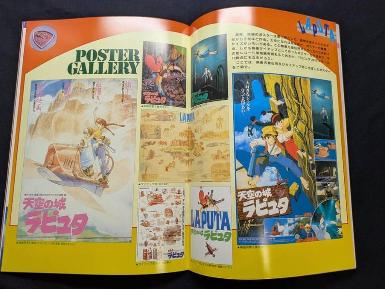 May include: An open book page titled POSTER GALLERY featuring a collection of colorful illustrations and movie posters for the film Laputa: Castle in the Sky. The layout includes various scenes with characters, Japanese text, and graphic designs.