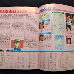 May include: A two-page spread from a Japanese publication featuring the text INTRODUCTION and PROFILE. The pages contain columns of Japanese text, character illustrations, and photographs of staff members, with a light pink background throughout.