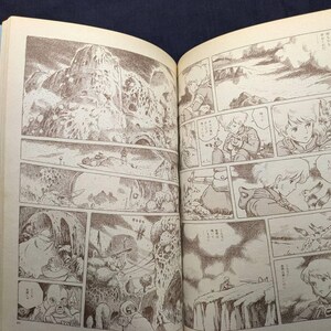 May include: Open book with sepia-toned manga illustrations. The panels depict scenes of a fantasy world with characters, landscapes, and action sequences. The artwork is detailed, with a focus on line art and shading.