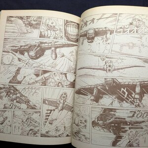 May include: Open book with sepia-toned illustrations. The artwork depicts a series of panels showing aircraft in flight and combat scenes. The style is reminiscent of a vintage comic book or manga.