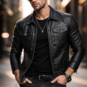 Può includere: Giacca di pelle nera con collo e due tasche sul petto. Indossata sopra una t-shirt nera e abbinata a jeans neri. Gli accessori includono occhiali da sole, orologio e collana d'argento.