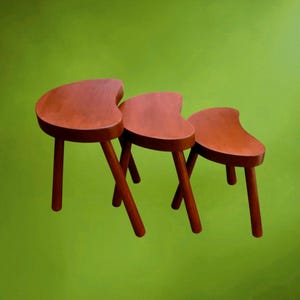 Juego de tres taburetes apilables de madera barnizada, con forma de judía - años 60-70