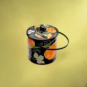 Peut inclure: Un récipient cylindrique en métal noir avec un couvercle assorti et une fine anse en fil de fer noir. L'extérieur présente un motif décoratif de citrouilles orange, de vignes vertes et de feuilles blanches. Un petit bouton noir est centré sur le couvercle.