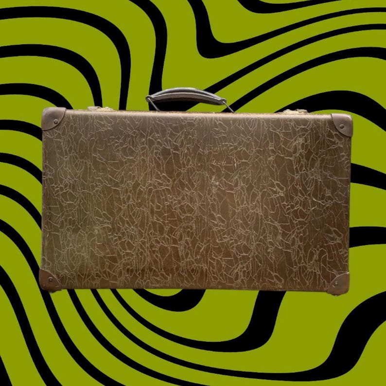 May include: A vintage brown suitcase with a textured surface and a handle. The corners are reinforced with metal. The background is a wavy pattern of black and green.