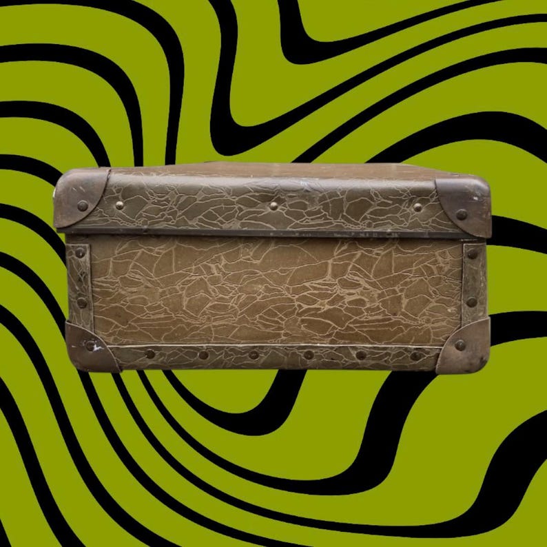 May include: A vintage brown trunk with metal corner protectors and rivets. The trunk has a textured surface and a rectangular shape. The background is a green and black wavy pattern.