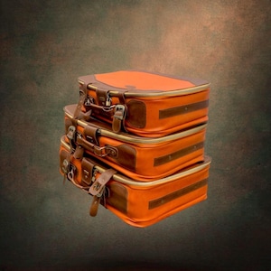 Peut inclure: Une pile de trois valises rectangulaires d'une couleur orange vive avec des garnitures en similicuir marron foncé, des boucles en métal et des coins renforcés. Chaque valise dispose d'une poignée, d'un mécanisme de fermeture et d'un design rigide.
