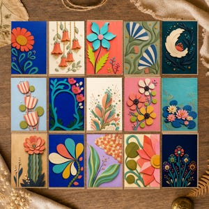 Peut inclure: Une collection de quinze cartes de vœux rectangulaires disposées en grille, chacune présentant des motifs floraux et botaniques en papier découpé superposé aux couleurs vives, notamment bleu, rose, orange, vert et jaune sur divers fonds.