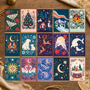 May include: A collection of fifteen rectangular greeting cards featuring diverse illustrations including moths, a Christmas tree, rabbits, mountains, bells, foxes, polar bears, deer, owls, whales, a sun, swans, narwhals, a moon, and a snow globe.