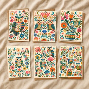 Könnte beinhalten: Sechs rechteckige Grußkarten mit farbenfrohen Illustrationen von Eulen, Blumen und Himmelsmotiven. Jede Karte zeigt eine einzigartige Anordnung gemusterter Eulen in Blau-, Orange- und Rosatönen, umgeben von botanischen Elementen.
