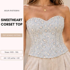 Könnte beinhalten: Ein herzförmiges Korsett-Oberteil aus hellblauem Stoff mit weißem Blumenmuster, vertikalen Stäbchenkanälen und geradem Saum. Der Text auf dem Bild umfasst AYLIN PATTERNS, SWEETHEART CORSET TOP, PDF SEWING PATTERN, Sizes: XXS - 5XL, A4, US Letter und A0.