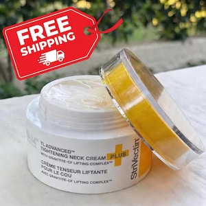 K&ouml;nnte beinhalten: Ein Tiegel TL Advanced Tightening Neck Cream Plus mit leicht ge&ouml;ffnetem Deckel. Der Tiegel ist wei&szlig; mit schwarzem Text und einem gelben Pluszeichen. Ein rotes Etikett mit "FREE SHIPPING" befindet sich im Hintergrund.