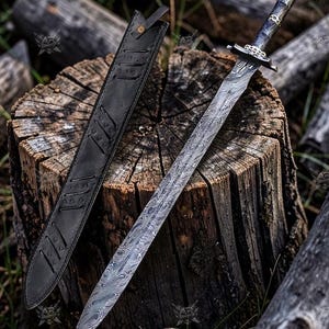 May include: A Damascus steel sword with a black leather sheath. The sword features a patterned blade and an ornate handle. The sheath is positioned beside the sword on a wooden stump, with logs in the background.