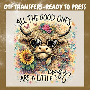 Peut inclure: Transferts DTF - Prêt à presser. Illustration fantaisiste d'une vache des Highlands portant des lunettes de soleil en forme de cœur et une couronne florale, tenant une fleur dans sa bouche. Le texte dit : « Tous les bons sont un peu fous. »