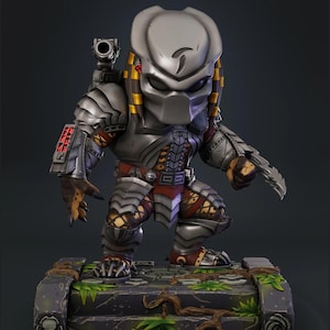 May include: A Predator figurine in a crouching pose, with a silver helmet and armour, and red and gold details. The figure is on a stone base with green foliage and brown roots, showing intricate details.