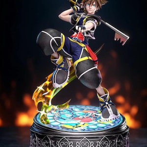 Op de afbeelding: Een gedetailleerd beeldje van een Kingdom Hearts-personage met een Keyblade. Het beeldje draagt blauwe, zwarte en gele kleding. De basis heeft een glas-in-lood ontwerp, en de achtergrond heeft een vurige gloed. Een verzamelobject.