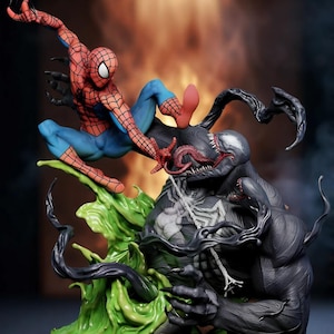 Puede incluir: Una detallada figura que representa una escena de batalla entre Spider-Man y Venom. Spider-Man está en una pose dinámica, vestido con su traje rojo y azul, mientras que Venom es una figura negra amenazante con un símbolo de araña blanco. La base presenta elementos verdes líquidos.