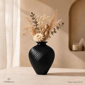 Puede incluir: Un jarrón negro mate con una textura acanalada en espiral contiene un ramo de plantas secas, que incluye una flor blanca grande, hierba de la pampa plumosa, tallos de eucalipto, paniculata y vainas de semillas redondas. El jarrón es abombado.