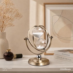 May include: A rotating hourglass with a metallic gold frame and a circular base. The glass bulbs contain white sand, held within a gimbal-style structure that allows for rotation. The hourglass is positioned on a flat surface.